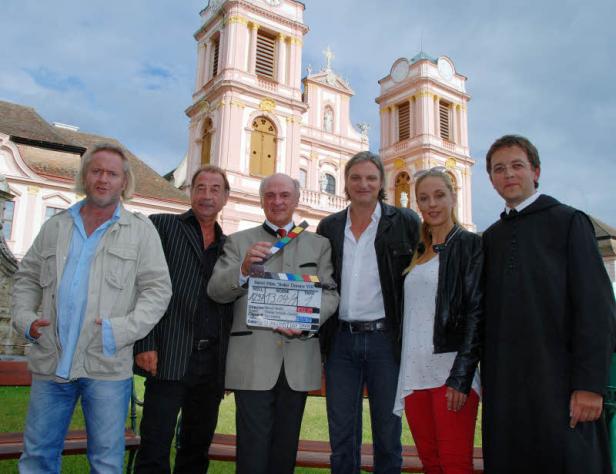 Die Besetzung von „Soko Donau VIII“ posiert vor dem Stift Melk mit einer Filmklappe.