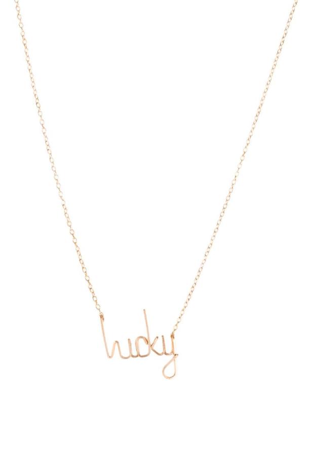 Eine goldene Halskette mit dem Schriftzug „Lucky“.