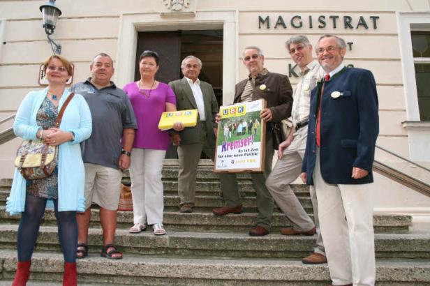 Eine Gruppe von Personen steht vor dem Magistrat Krems mit Wahlplakaten der Liste UBK.