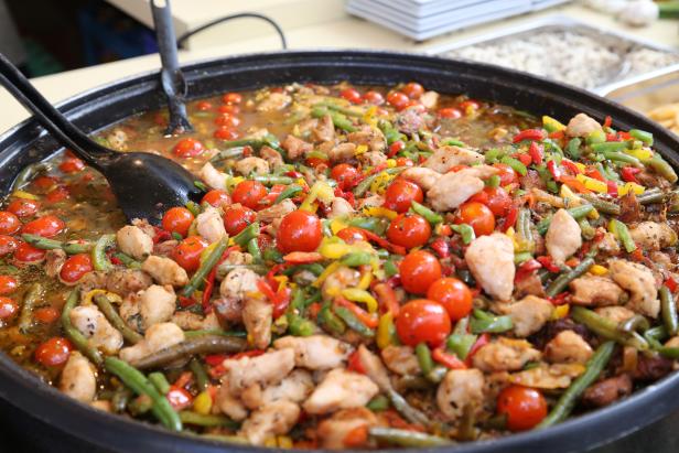 Eine große Pfanne mit Hähnchen, grünen Bohnen, Paprika und Kirschtomaten.