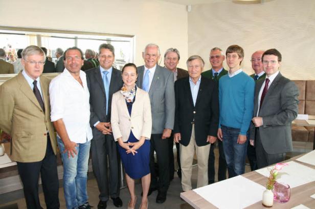 Eine Gruppe von Menschen posiert für ein Foto in einem Innenraum. Eine Gruppe von Menschen posiert für ein Foto in einem Innenraum.
