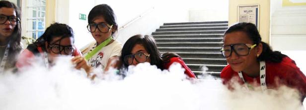 Eine Gruppe von Kindern mit Schutzbrillen experimentiert mit Trockeneis.