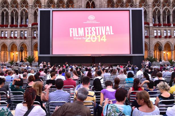 Zuschauer sitzen vor einer großen Leinwand beim Film Festival am Wiener Rathausplatz 2014.
