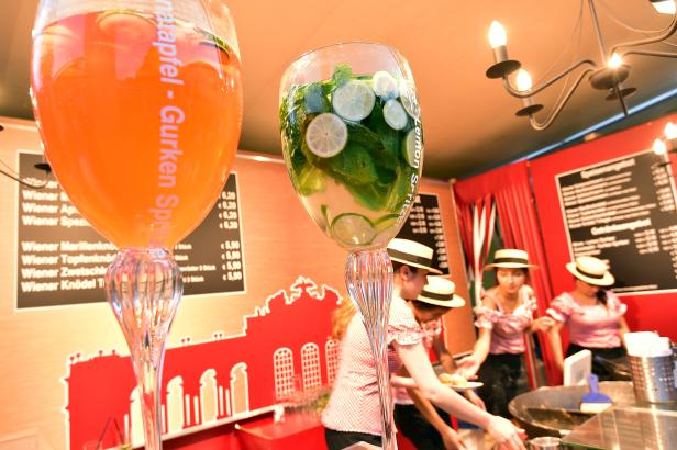 Zwei große Gläser mit Getränken, eines mit Gurke und Apfel, das andere mit Limette und Minze.