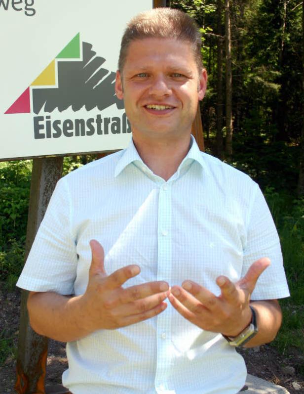 Ein Mann steht vor einem Schild mit der Aufschrift „Eisenstraße“.