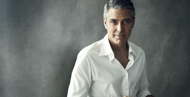 Porträt von George Clooney vor einem grauen Hintergrund.
