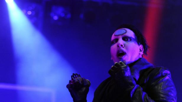 Marilyn Manson tritt in einem schwarzen Lederoutfit auf einer Bühne auf.