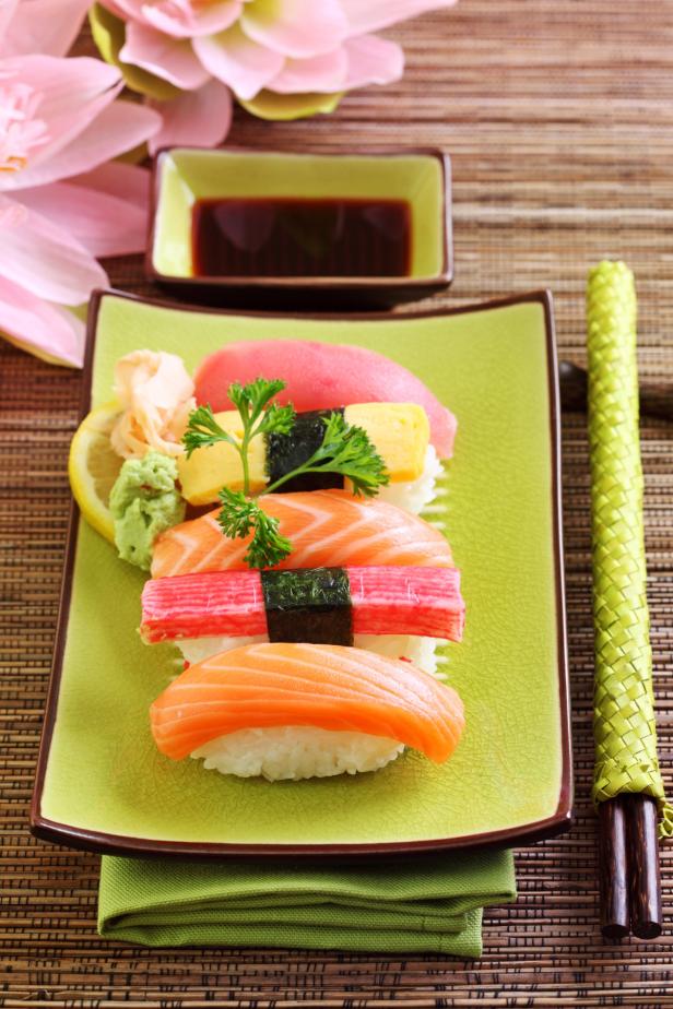 … Eine Platte mit verschiedenen Sushi-Sorten, darunter Lachs, Thunfisch und Krebsfleisch.