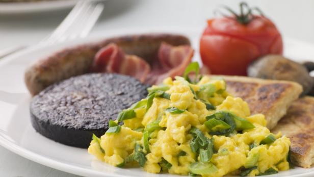 Ein Teller mit einem traditionellen irischen Frühstück mit Rührei, Blutwurst, Speck und Wurst.