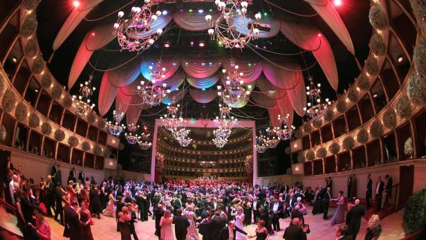 Ein Ballsaal mit vielen Menschen, die tanzen, und Kronleuchtern an der Decke.