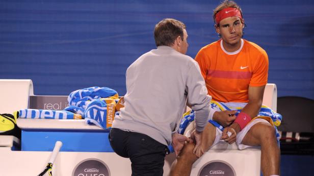 Rafael Nadal wird während eines Tennisspiels am Knie behandelt.