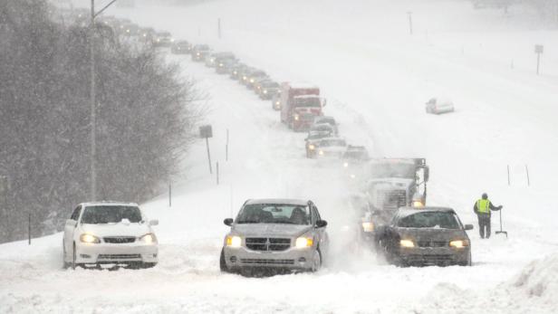 Schneefall behindert den Verkehr auf einer Autobahn.