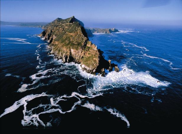 Luftaufnahme des Cape Point mit schäumenden Wellen an der Küste.