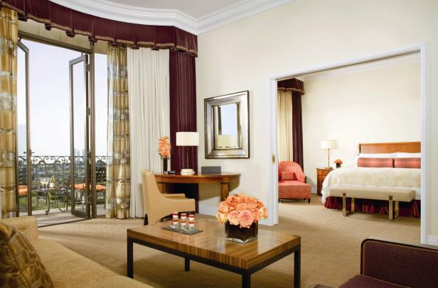 Ein luxuriöses Hotelzimmer mit Wohnbereich, Balkon und Blick in ein Schlafzimmer.