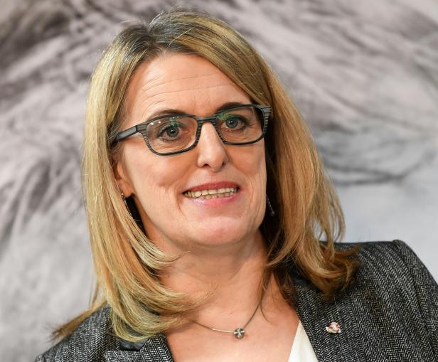 Eine Frau mit Brille lächelt in die Kamera.