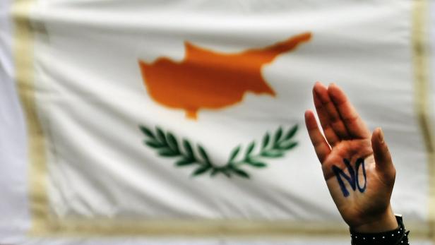Student raises her hand by Cypriot flag during an