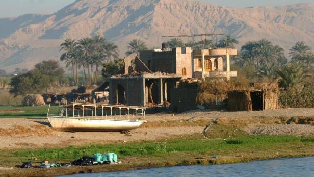 Ein Hausruine und ein Boot am Ufer des Nils in Ägypten.
