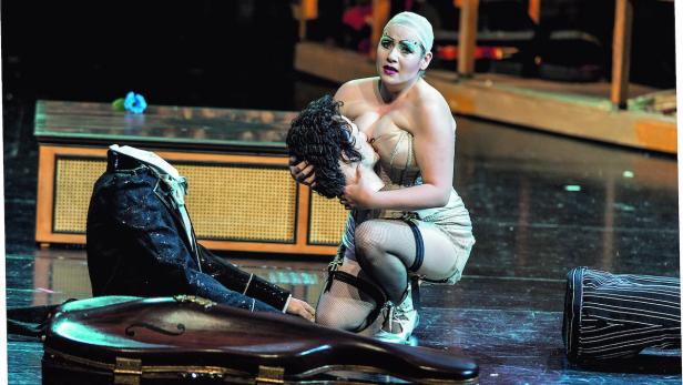 Mandy Fredrich als Antonia mit einer Hoffmann-Puppe. Sie ist im Bregenzer Festspielhaus auch als Giulietta zu hören Eine Frau im Kostüm kniet neben einer Puppe ohne Kopf auf einer Bühne.