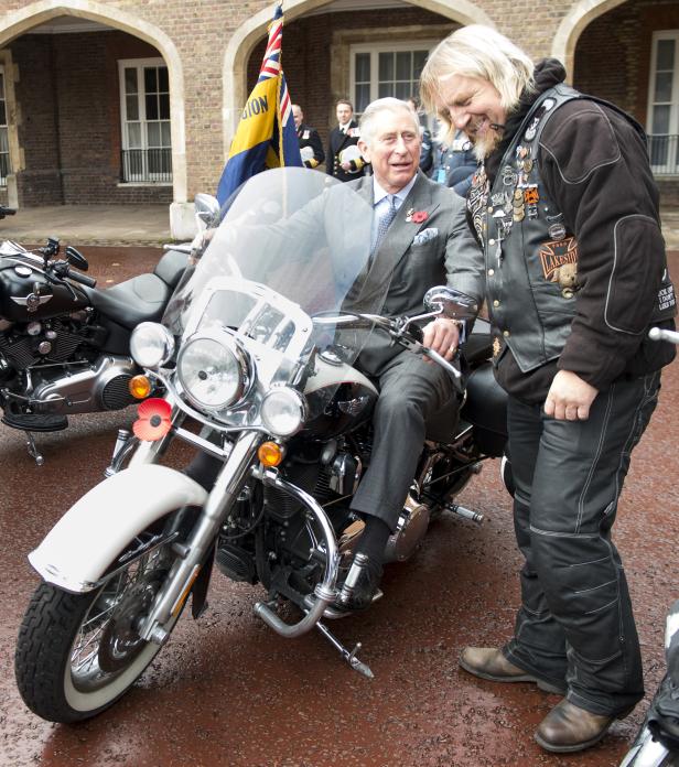 König Charles sitzt auf einem Motorrad und spricht mit einem Biker.