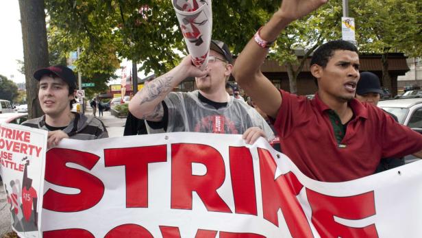 Demonstranten halten ein Banner mit der Aufschrift „Strike Poverty“ in Seattle.