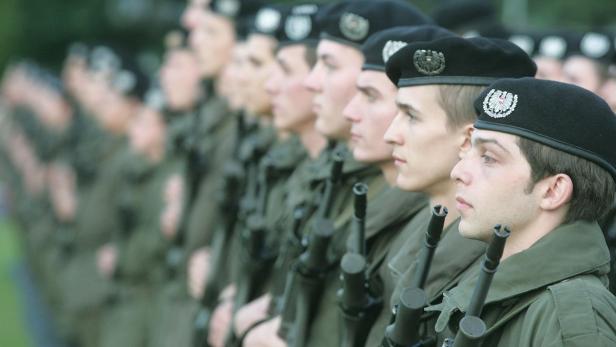Eine Reihe österreichischer Soldaten in Uniform und Barett steht stramm.