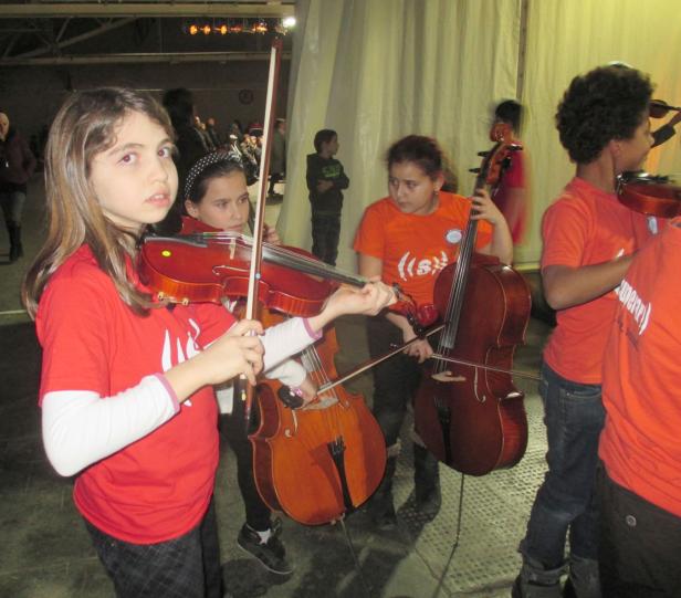 Eine Gruppe junger Musiker spielt Geige und Cello.