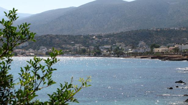 Blick auf eine Küstenstadt mit einem Berg im Hintergrund.
