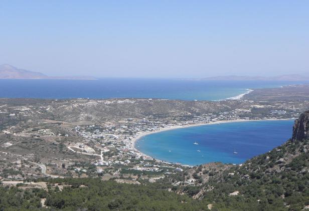 Ein Panoramablick auf eine Küstenstadt mit einem langen Sandstrand und blauem Meer.
