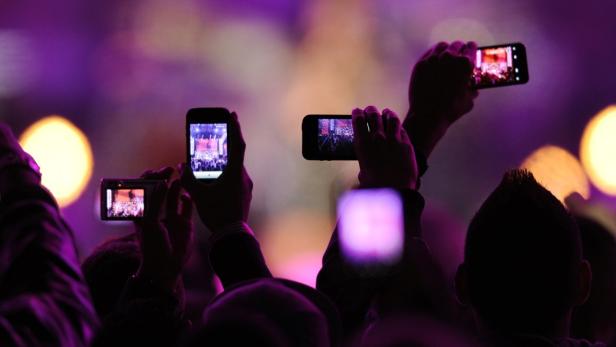 Zuschauer filmen ein Konzert mit ihren Smartphones.