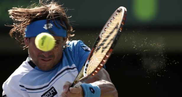 Ein Tennisspieler schlägt einen Ball mit seinem Schläger.