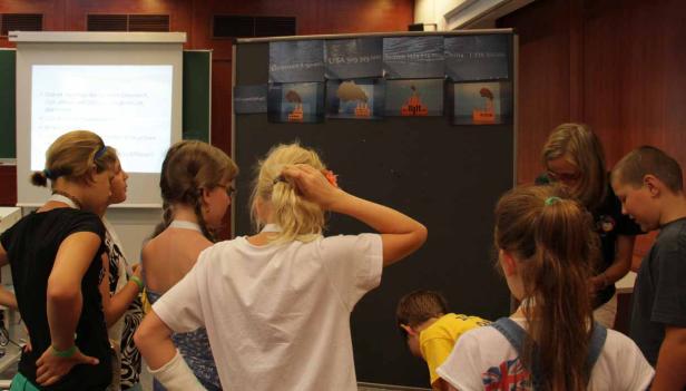 Eine Gruppe von Kindern betrachtet eine Präsentation über Umweltverschmutzung.