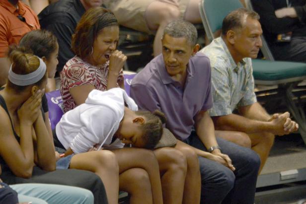 Barack Obama sitzt mit seiner Familie bei einer Veranstaltung.