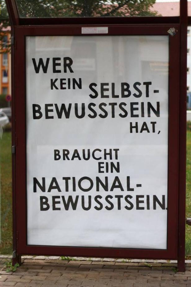 Ein Plakat an einer Bushaltestelle mit der Aufschrift: Wer kein Selbstbewusstsein hat, braucht ein Nationalbewusstsein.
