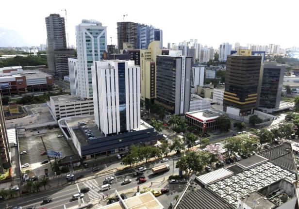 Luftaufnahme einer Stadtlandschaft mit Hochhäusern und Straßenverkehr.