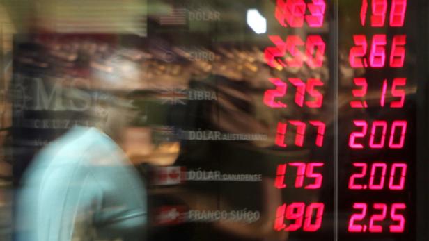 Eine Anzeigetafel zeigt Wechselkurse für verschiedene Währungen wie Dollar, Euro und Pfund an.