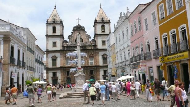 Eine belebte Straße in Salvador, Brasilien, mit einer Kirche im Hintergrund.