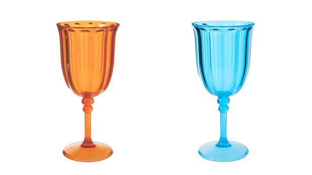 Zwei gerippte Weingläser in Orange und Blau stehen nebeneinander.
