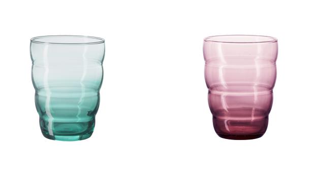 Zwei gerippte Trinkgläser in Grün und Rosa stehen nebeneinander.