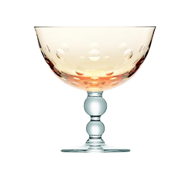 Ein bernsteinfarbenes Cocktailglas mit Punktmuster und einem Stiel aus Glaskugeln.