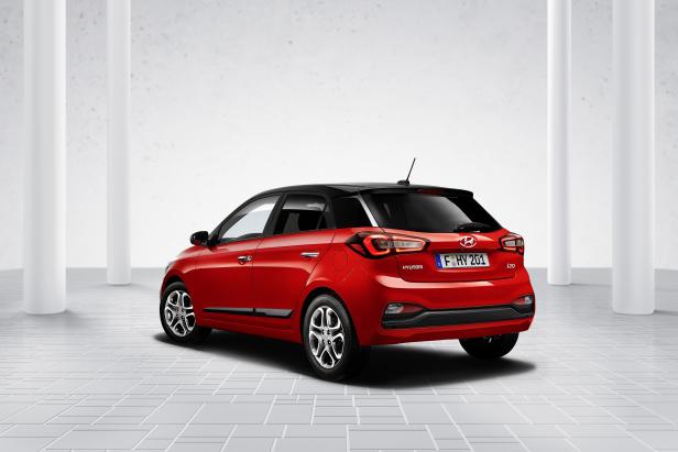 Ein roter Hyundai i20 mit schwarzem Dach, von hinten fotografiert.