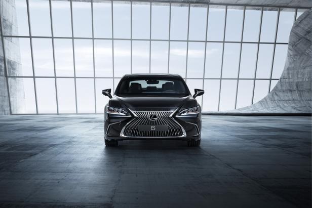 Ein schwarzer Lexus ES steht in einem modernen Gebäude mit großen Fenstern.