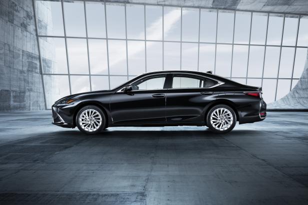 Eine schwarze Lexus Limousine steht in einem modernen Gebäude mit großen Fenstern.