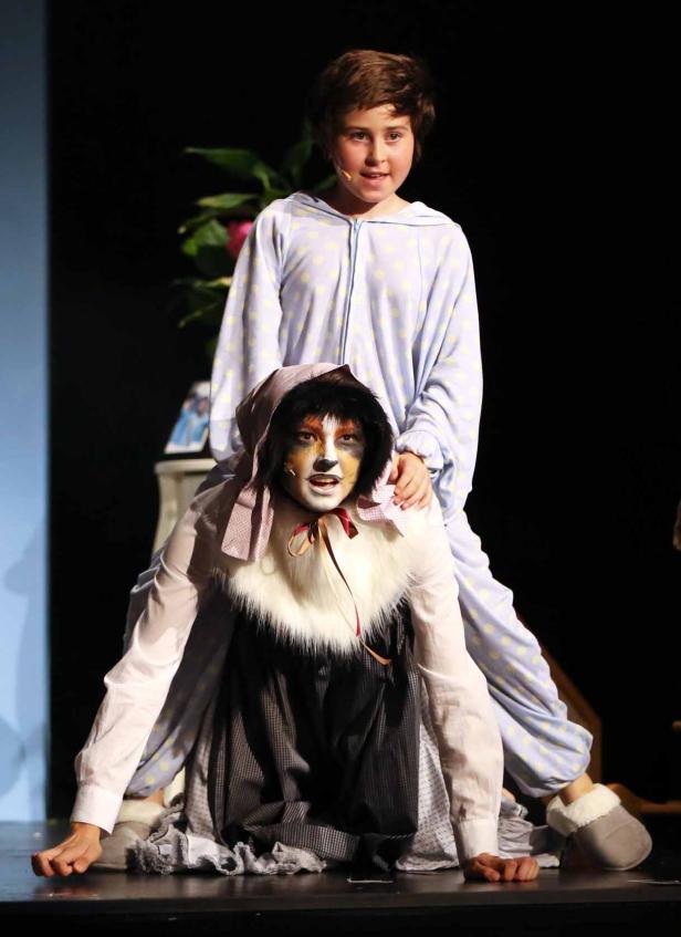 Zwei Kinder in Kostümen stehen auf einer Bühne.