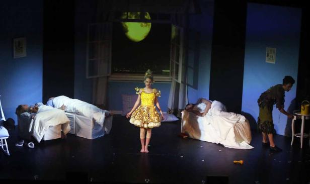 Szene aus einer Theateraufführung von Peter Pan mit Wendy im Vordergrund.