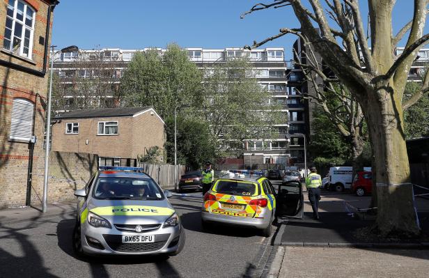 Police officers enforce a cordon at the scene where a teenager was found after being shot in London Police officers enforce a cordon at the scene where a teenager was found after being shot in London