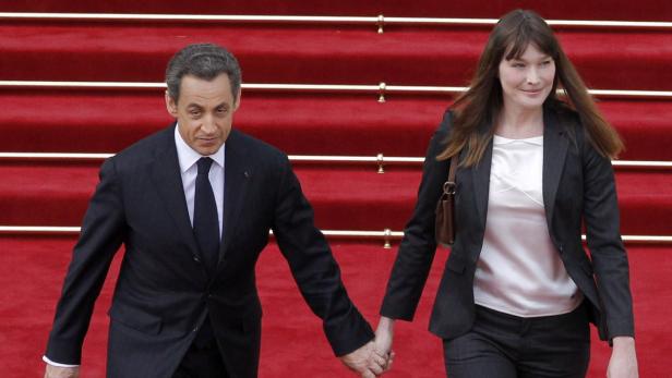 Nicolas Sarkozy und Carla Bruni Nicolas Sarkozy und Carla Bruni gehen Händchen haltend auf einem roten Teppich.