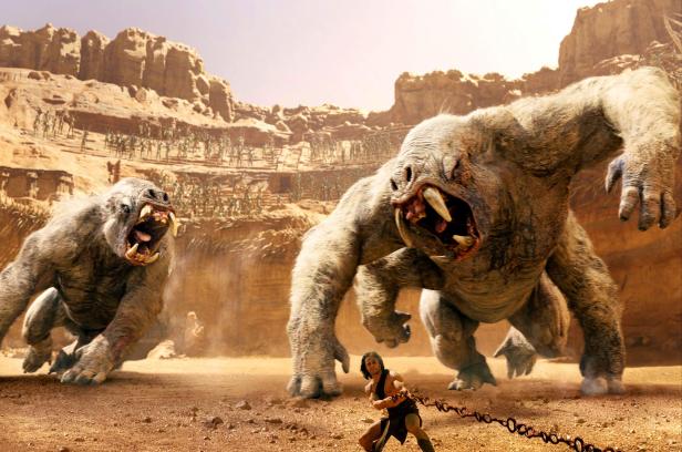 John Carter kämpft mit Ketten gegen zwei weiße, zahnstarrende Monster in einer Wüstenlandschaft.