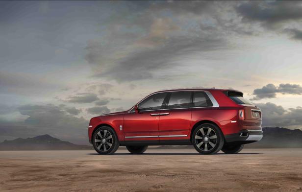 Ein roter Rolls-Royce Cullinan steht in einer Wüstenlandschaft.