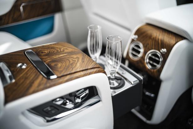 Zwei Champagnergläser stehen in der luxuriösen Innenausstattung eines Autos.