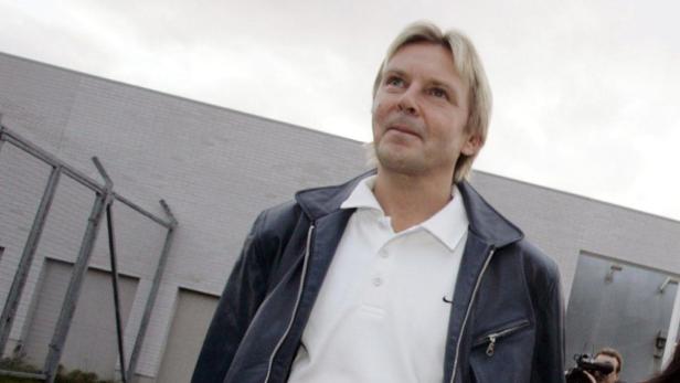 Ein Mann mit blonden Haaren und Lederjacke blickt nach oben.